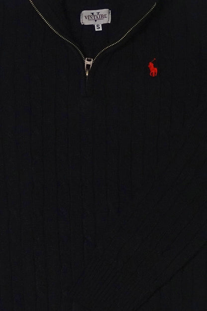 Close-up of a black sweater with a red embroidered logo on a dark background