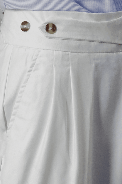 Close-up of light gray pants with a button and zipper detail.